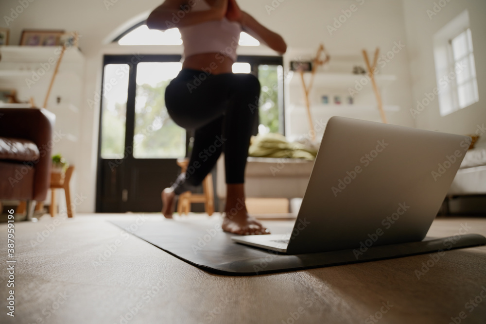 Closeup of laptop on fitness mat with young woman practising yoga exercise with help of online video - obrazy, fototapety, plakaty 