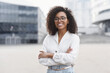 Leinwandbild Motiv Young businesswoman in a city looking at camera, African-american student girl portrait, Young woman with crossed arms smiling, People, enjoy life, student lifestyle, city life, business concept