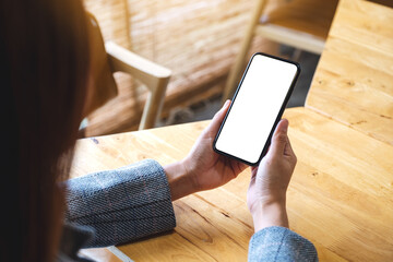 mockup image of a woman holding mobile phone with blank white desktop screen