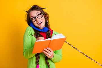 Sticker - Close-up portrait of attractive funky cheerful girl talking on phone writing home task discussing isolated bright yellow color background