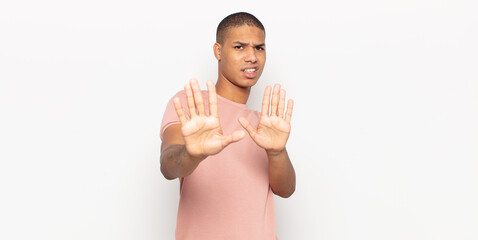 Wall Mural - young black man feeling terrified, backing off and screaming in horror and panic, reacting to a nightmare