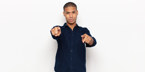 Wall Mural - young black man pointing forward at camera with both fingers and angry expression, telling you to do your duty