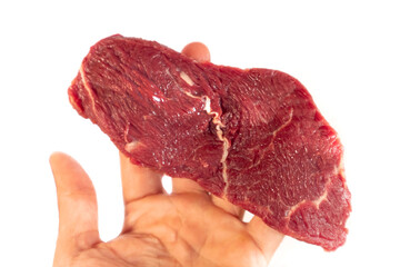 The man holds a raw steak. Fresh raw beef steak isolated on white background.