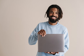 Wall Mural - Happy african american guy smiling and holding laptop