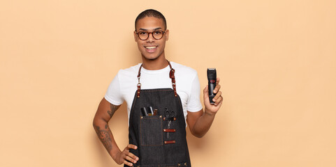 Wall Mural - young black man smiling happily with a hand on hip and confident, positive, proud and friendly attitude