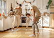 © JenkoAtaman - Energetic multiracial family playing in kitchen.