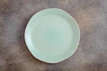 Empty green irregular plate on concrete background. Top view, with copy space