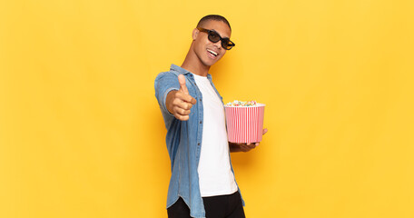 Wall Mural - young black man feeling proud, carefree, confident and happy, smiling positively with thumbs up