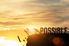 Businessman Push Impossible Wording To Possible Wording On Top Of Mountain With Sunlight. Positive Mindset Concept.