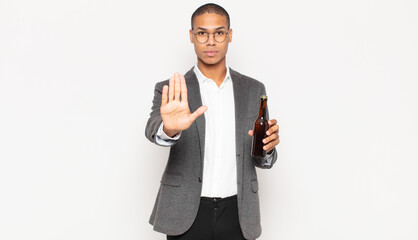 Sticker - young black man looking serious, stern, displeased and angry showing open palm making stop gesture