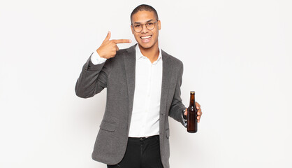 Wall Mural - young black man smiling confidently pointing to own broad smile, positive, relaxed, satisfied attitude