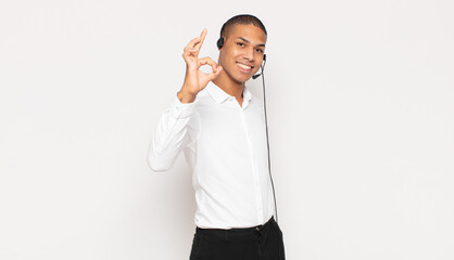 Wall Mural - young black man feeling happy, relaxed and satisfied, showing approval with okay gesture, smiling