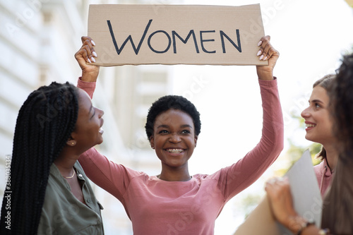 Fotografía Cheerful black woman holding placard, fighting for women rights