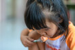 © banhan - A 3-year-old Asian girl eating hot dog.