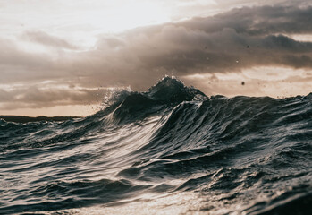 moody waves crash with sun breaking through
