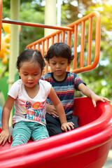 Wall Mural - Asian girl and asian boy is enjoy on a playground