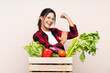 © luismolinero - Farmer Woman holding fresh vegetables in a wooden basket making strong gesture