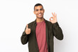 © luismolinero - Young African American man over isolated white background showing ok sign and thumb up gesture