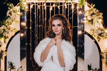 Wall Mural - Portrait of the bride against the background of garlands. Summer evening.