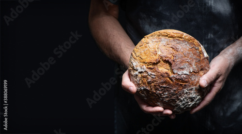 Fotomural Baker's hands holding and presenting fresh baked loaf of bread