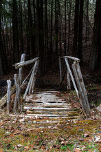 A Old Abandoned Rickety Bridge Leads Across A Small Stream And Into A Dark And Creepy Forest Near The Small Town Of Mulmur, Ontario.