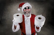© soupstock - Santa Claus wearing sunglasses and holding rolls of toilet paper as gifts during pandemic