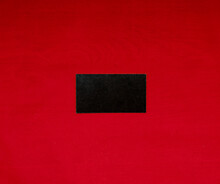 Tne Black Card Without Inscriptions Lies On A Red Background In The Center