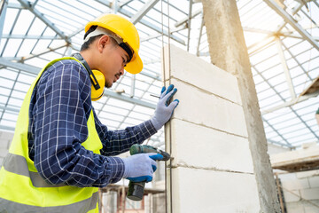Aufkleber - Closeup of a construction worker hands using a drill on a construction site.