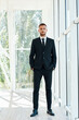 © GVS - Full length portrait of confident businessman in elegant suite posing in modern creative office