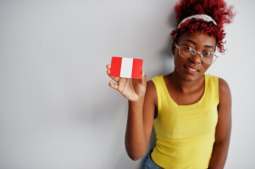 Wall Mural - African american woman with afro hair, wear yellow singlet and eyeglasses, hold Peru flag isolated on white background.