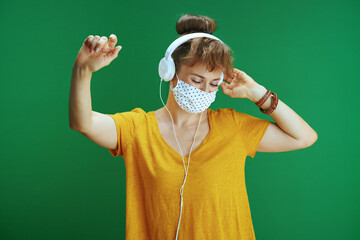 Wall Mural - student dancing and listening to music isolated on green