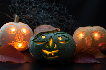 Three carved pumpkins glowing on black background