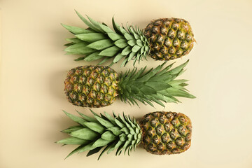  Fresh ripe juicy pineapples on beige background, flat lay