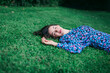 © Alexandra C. Ribeiro/Westend61 - Young woman with eyes closed lying on grassy land in park