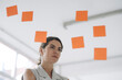 © KNSY/Westend61 - Thoughtful businesswoman standing by glass wall at office