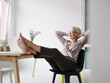 © Kniel Synnatzschke/Westend61 - Businesswoman with hands behind head relaxing on chair in loft office