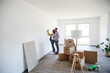 © MiJo/Westend61 - Couple trying light fixture on wall at new home