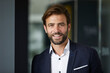 © Rainer Berg/Westend61 - Businessman smiling while standing at office