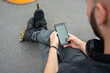© Vasily Pindyurin/Westend61 - Close-up of young man wearing inline skates using smart phone while sitting on street