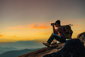 the hat binoculars are placed on the map in the beautiful landscape of the mountains.