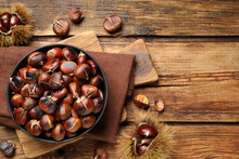 Delicious Roasted Edible Chestnuts On Wooden Table, Flat Lay. Space For Text