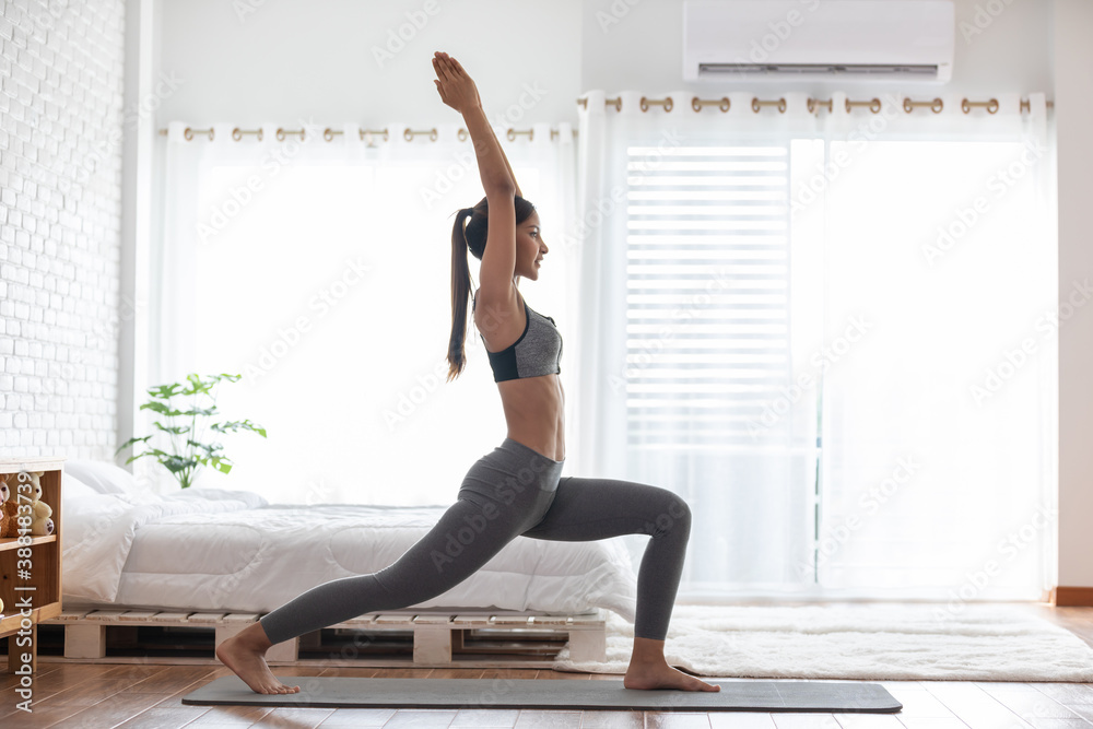 Athletic Healthy Asian indian woman in sportswear workout excercise at home in bedroom,Young woman with slim body cardio aerobic exercises healthy lifestyle concept - obrazy, fototapety, plakaty 