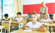 © JackF - Portrait of focused tween schoolgirl sitting on lesson in classroom, looking confidently at camera