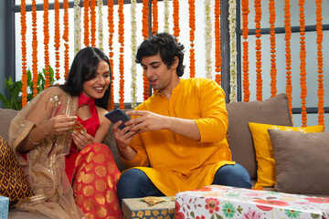 Handsome young man showing a photo on his phone to a beautiful girl	