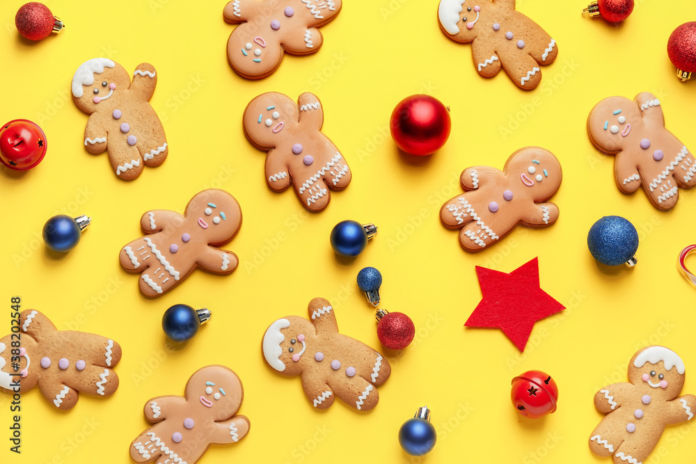 Tasty gingerbread cookies and Christmas decor on color background