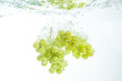 Fresh Muscat white Grapes Falling Into Water with splash Isolated on White Background