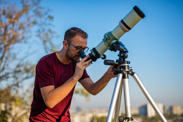 Wall Mural - amateur astronomer looking at the sky with a telescope.