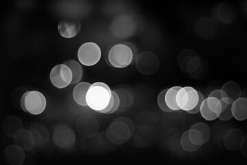 Blurry light circles background in black and white. Black abstract background in blur.