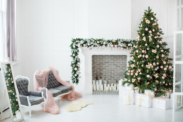 Wall Mural - Interior with light walls, fireplace and soft pink sofa decorated for celebrating Christmas. Comfort home in Christmas or New Year Holidays