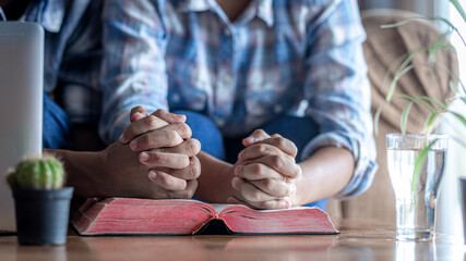 Wall Mural - Close up hands praying of two person with Bible at home, church in home, Home church during quarantine coronavirus Covid-19, Religion concept.